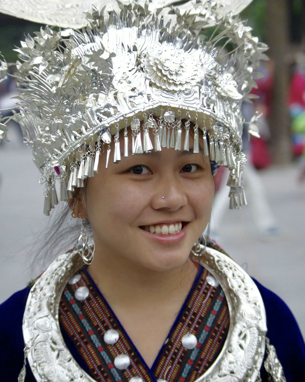 Natasha at Xijiang Miao Village in Guizhou, wearing a tall silver headdress with hanging bells and a wide silver collar.